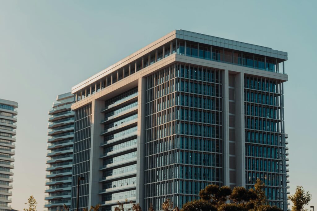 A modern highrise building with glass facade against a clear sky, showcasing urban architecture.
