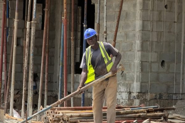 Construction worker operating at a building site, showcasing industry and development.